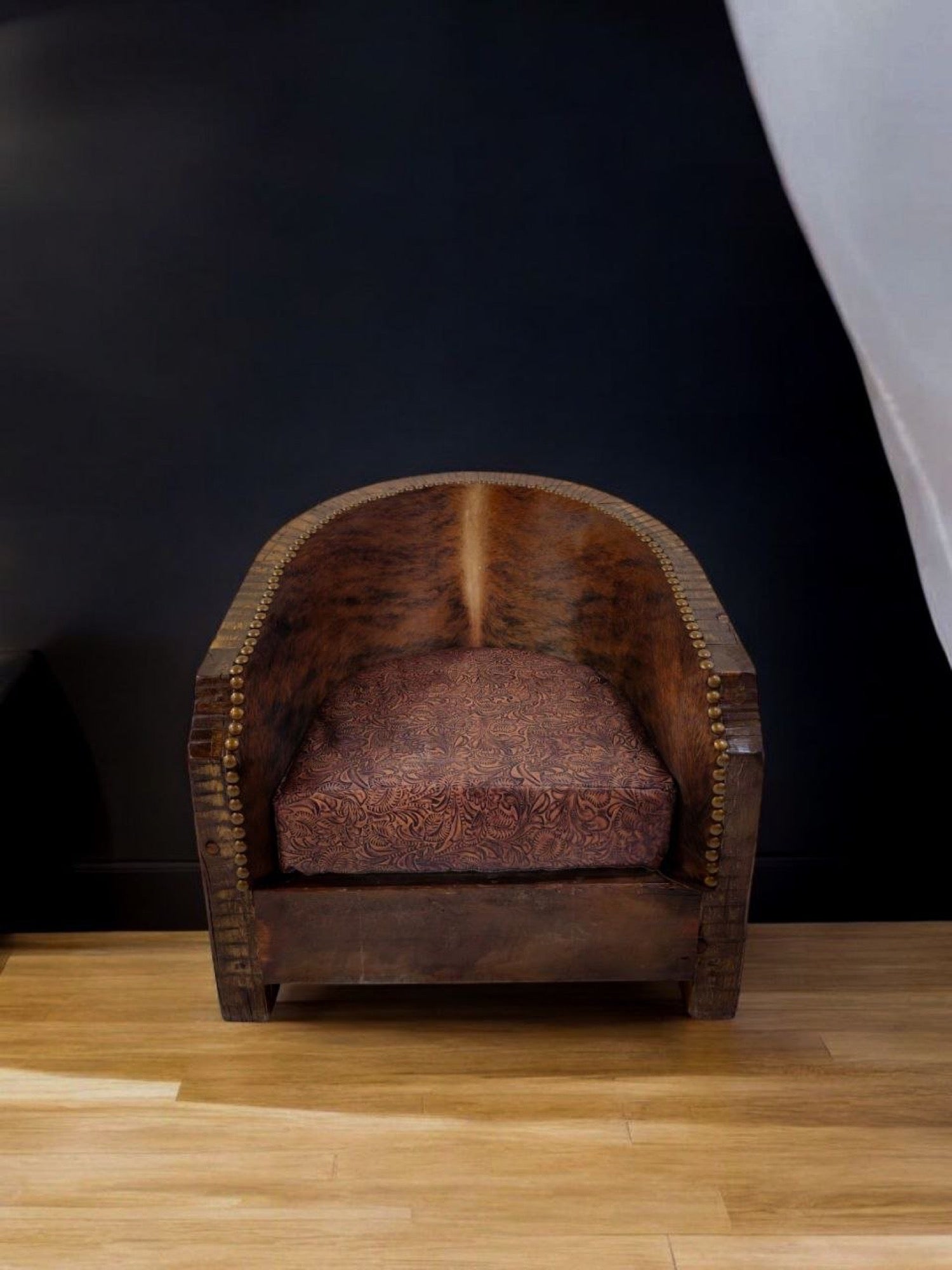Vintage leather armchair with ornate cushion