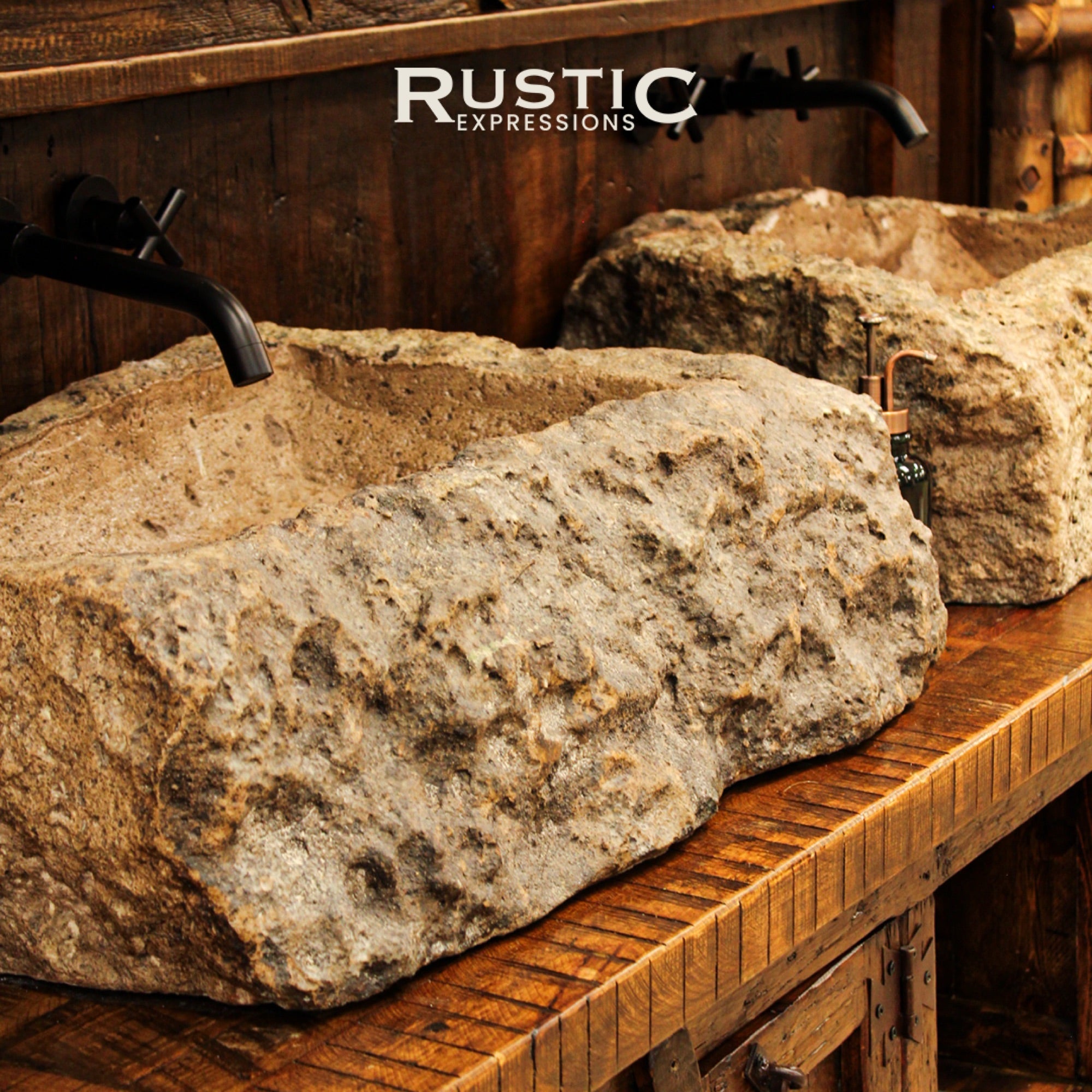 Rustic stone sinks with black faucets on a wooden vanity