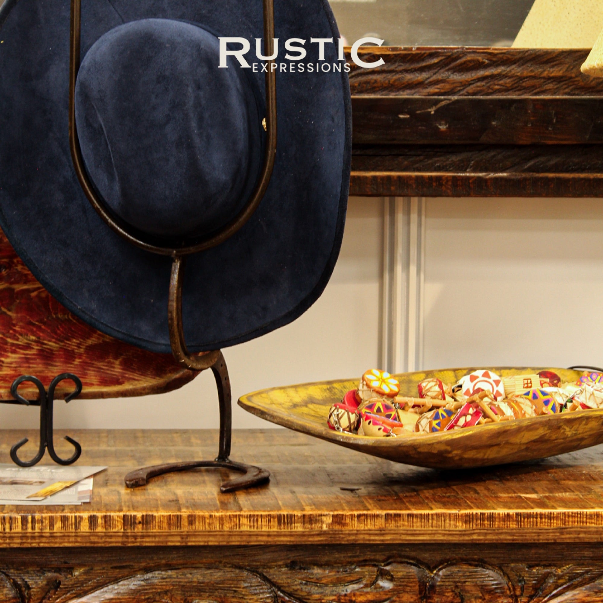 Cowboy hat on a stand with a wooden bowl on a rustic table